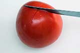 Make a cross cut on the bottom of tomato. This will facilitate the peeling.