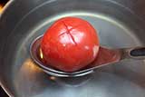 Bring water to a low boil, insert tomatoes for about 20 seconds. Do not do more than 4 tomatoes at the time. Using draining spoon helps a lot.