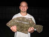 Adam Marianski holding a large Floridian gulf flounder<em> (Paralichthys albiguttata)</em>.