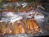 Packing smoked mullet into sealable plastic bags.