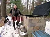 Adding sausage into a smoker.